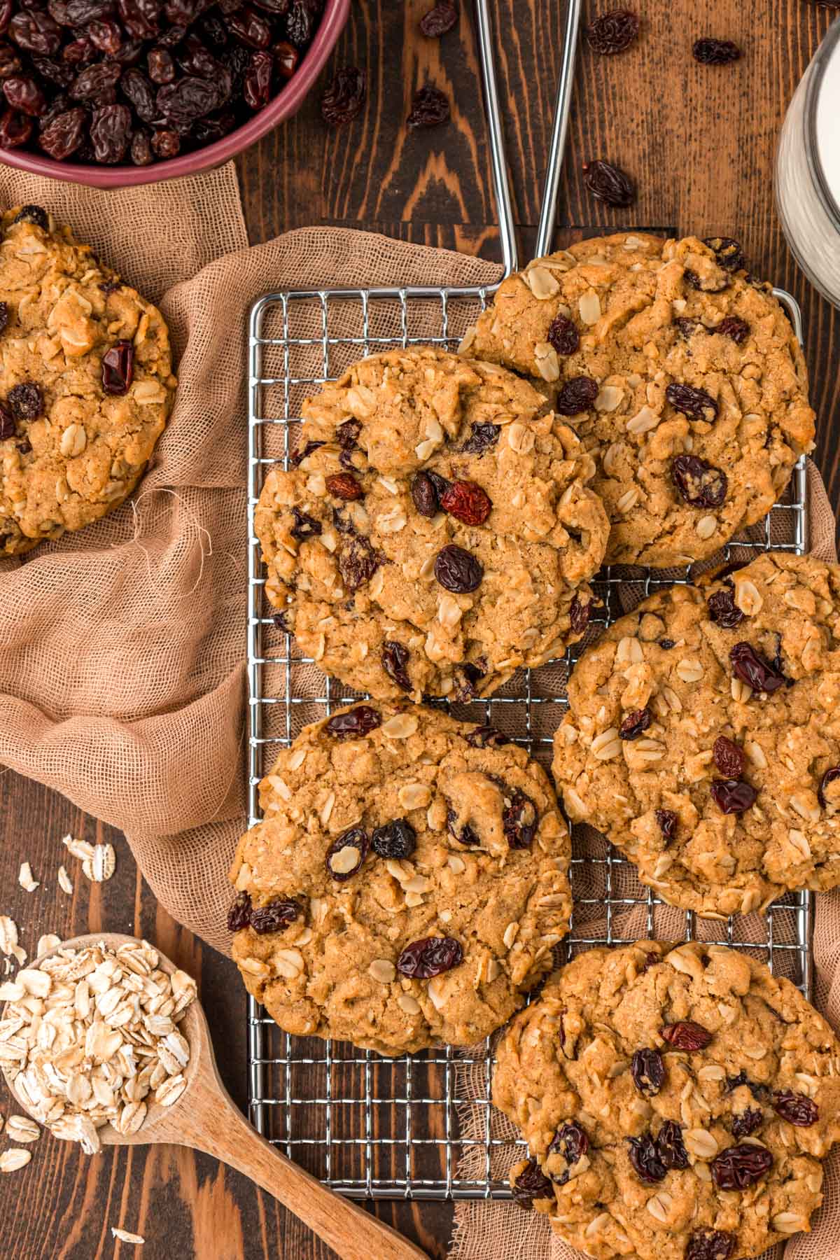 Overhead photo of oatmeal raisin cookies on a wire rack on a wooden table.