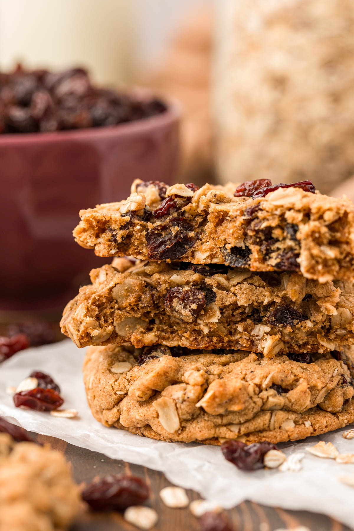 A stack of oatmeal raisin cookies, the top ones have been broken in half.