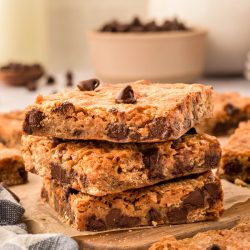 A stack of three graham cracker bars on a wooden board.