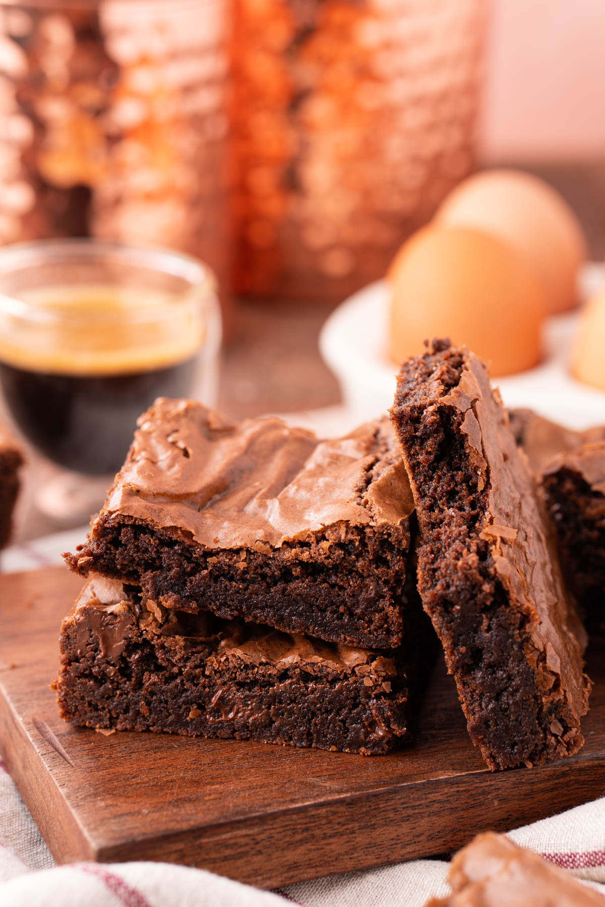 Two brownies stacked on top of each other with one leaning against them with a bite missing.