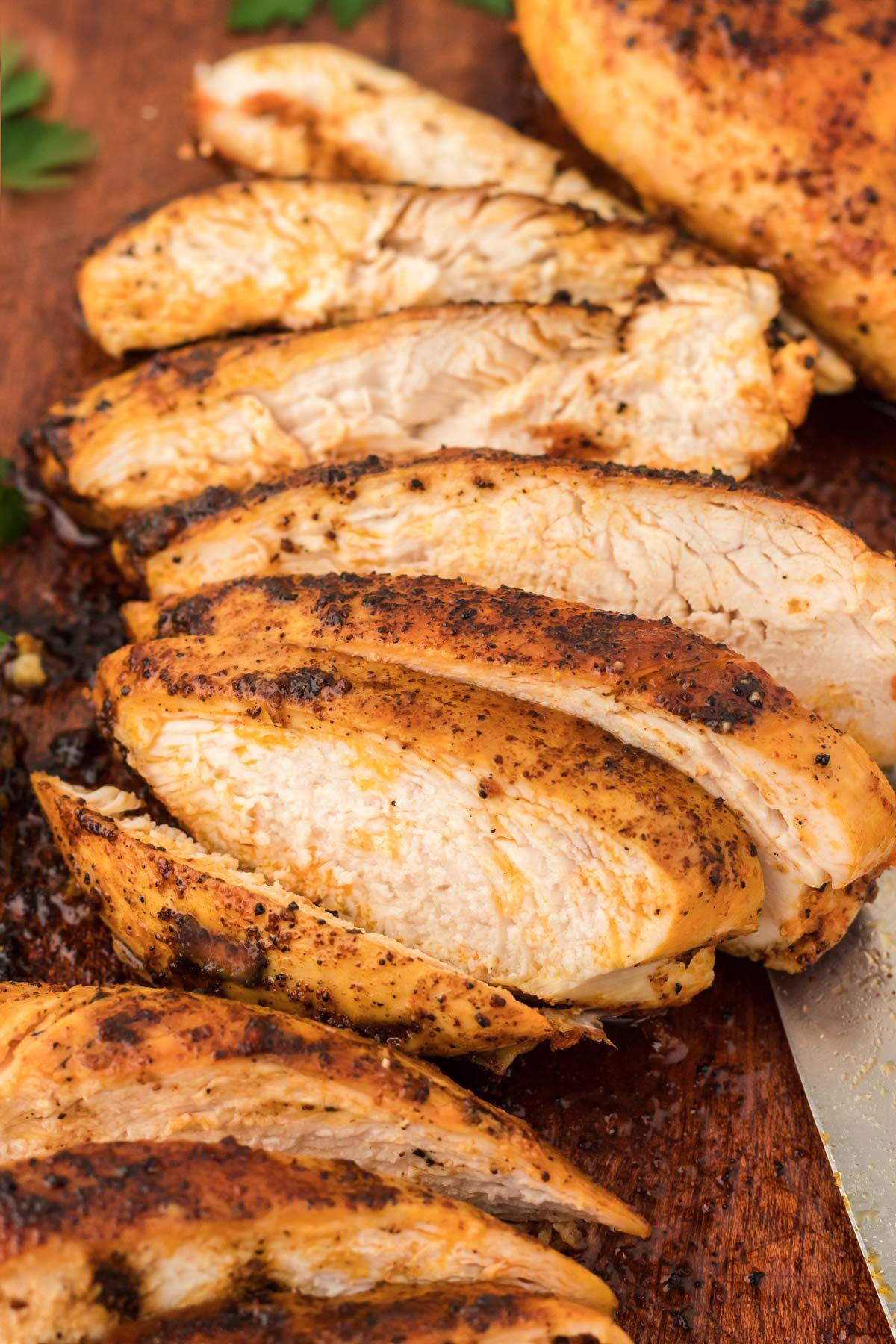 Juicy Chicken Breasts sliced up on a cutting board. 