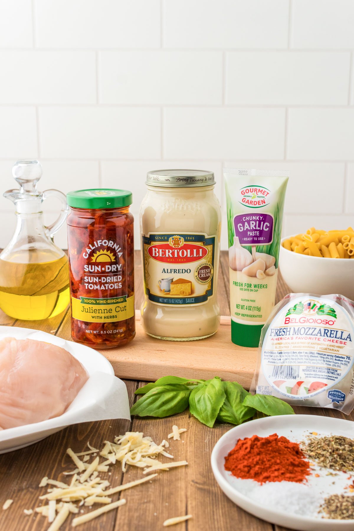 Ingredients to make Marry Me Chicken Pasta on a wooden table.