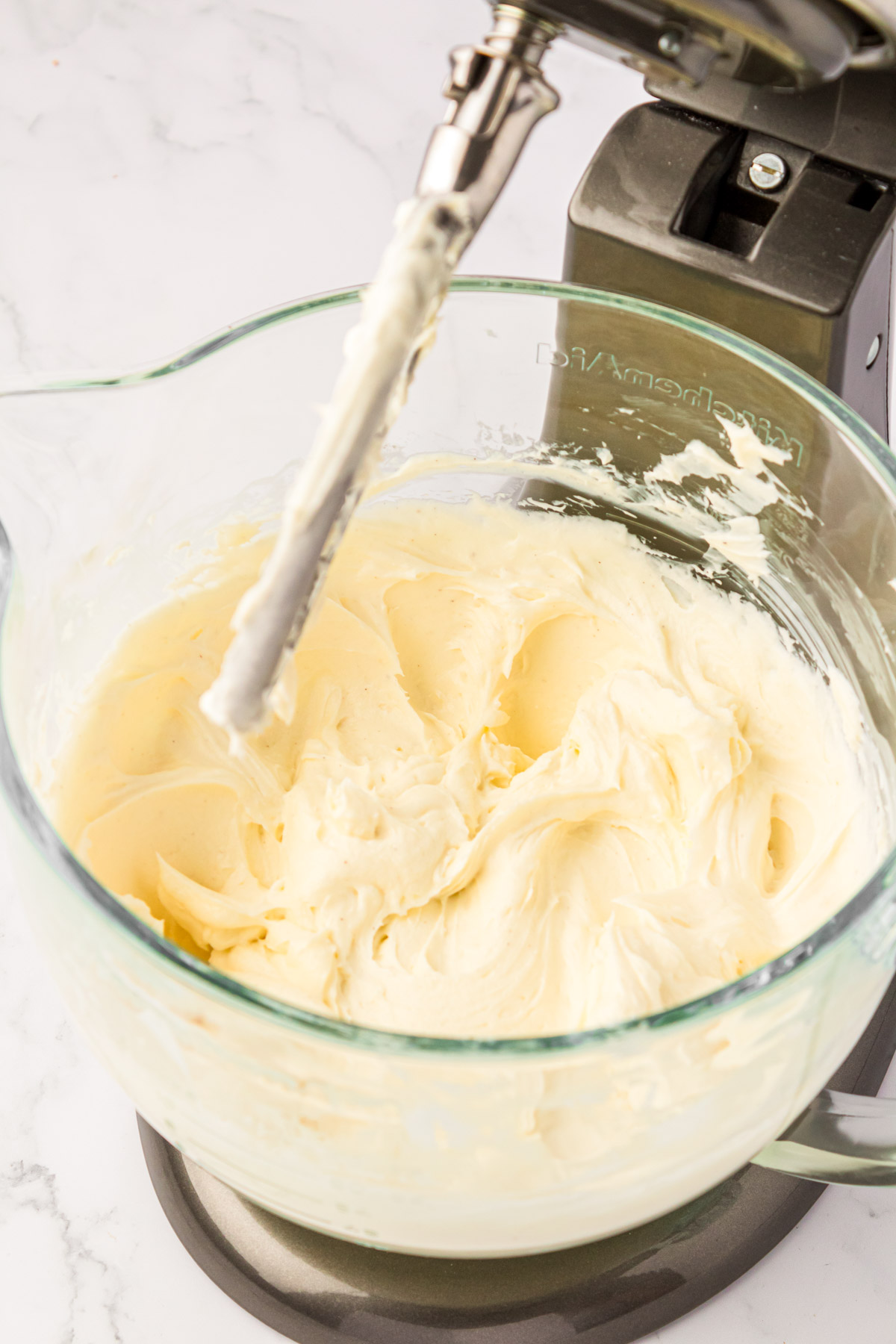 Cheesecake filling being prepared in a mixing bowl.