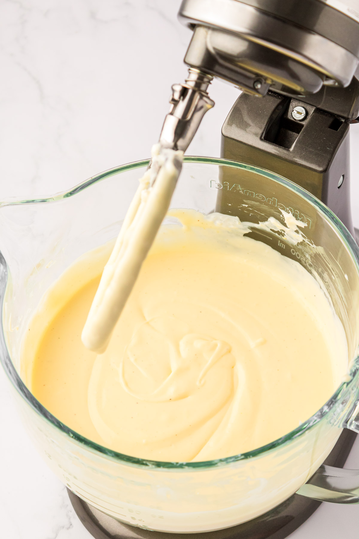 Cheesecake filling in a glass stand mixer bowl.