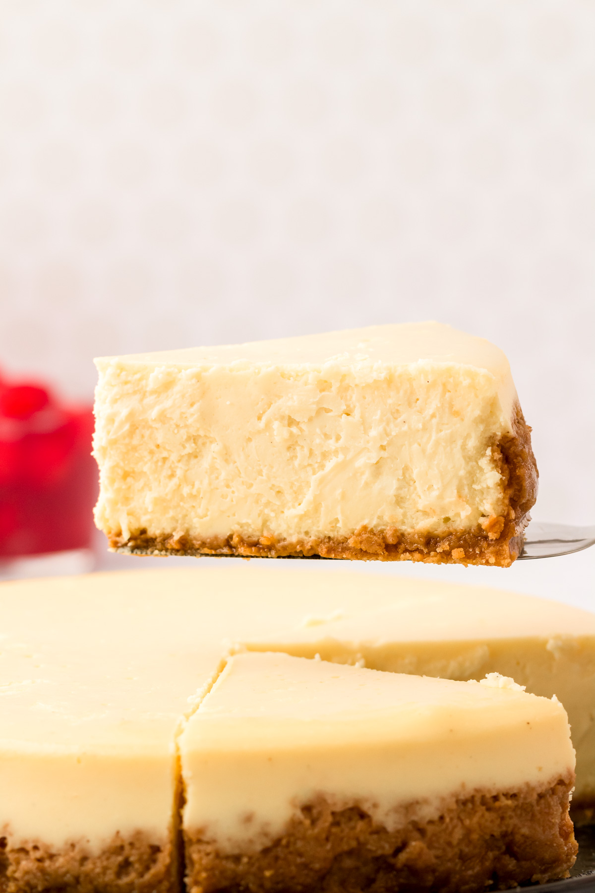A slice of cheesecake being lifted from the whole.