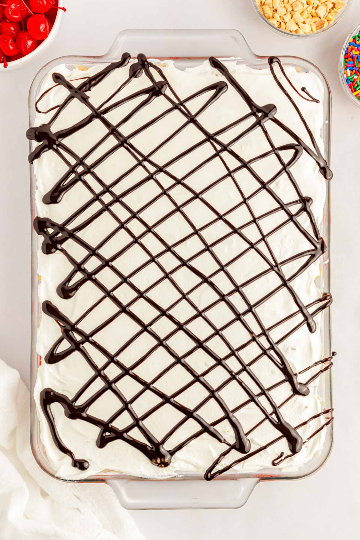 Chocolate drizzled over cool whip in a pan.