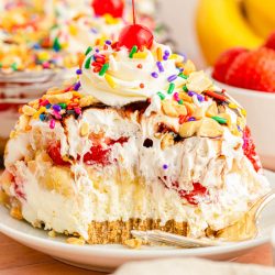 A slice of no bake banana split cake on a white plate.