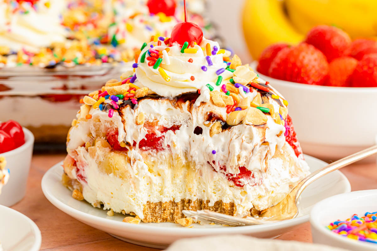 A slice of no bake banana split cake on a white plate.