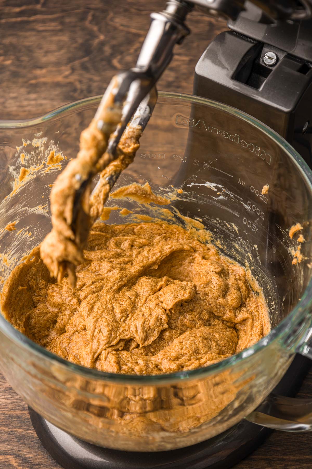 Pumpkin cookie dough being mixed in a stand mixer.