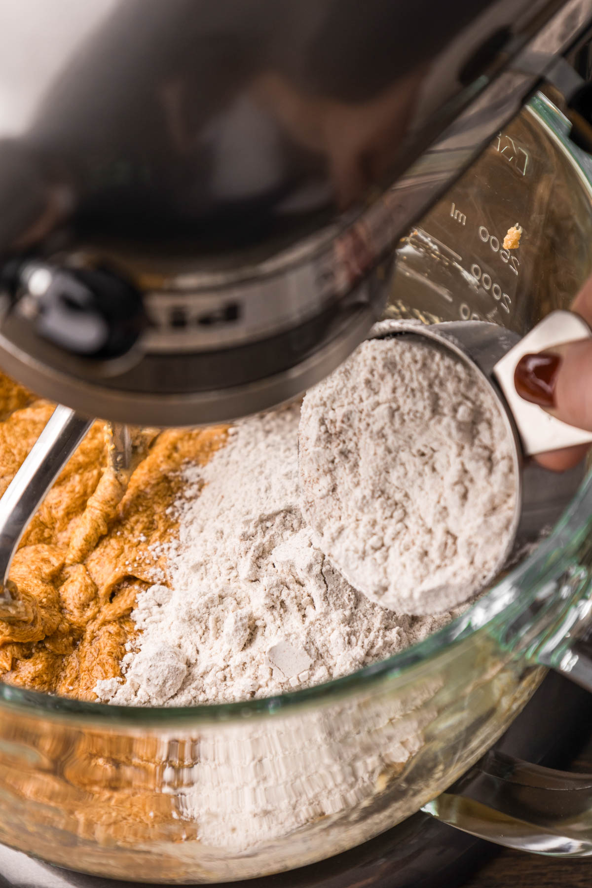 Dry ingredients being added to wet ingredients to make pumpkin cookie dough.