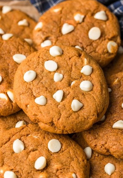 Close up photo of pumpkin white chocolate chip cookies in a pile.