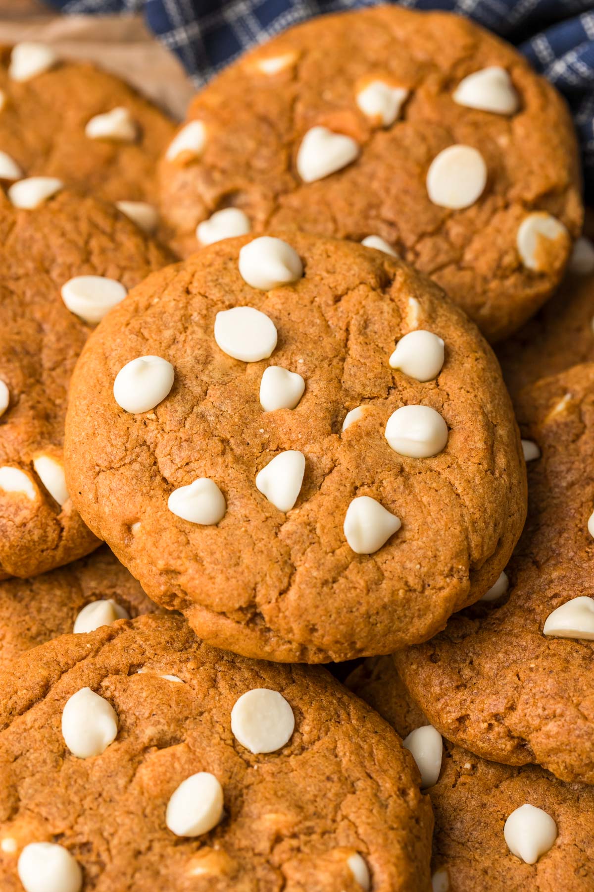 Close up photo of pumpkin white chocolate chip cookies in a pile.