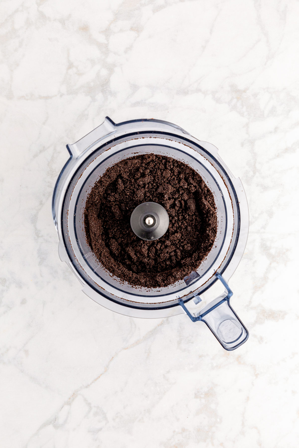 Overhead photo of a food processor with processed Oreos in it.