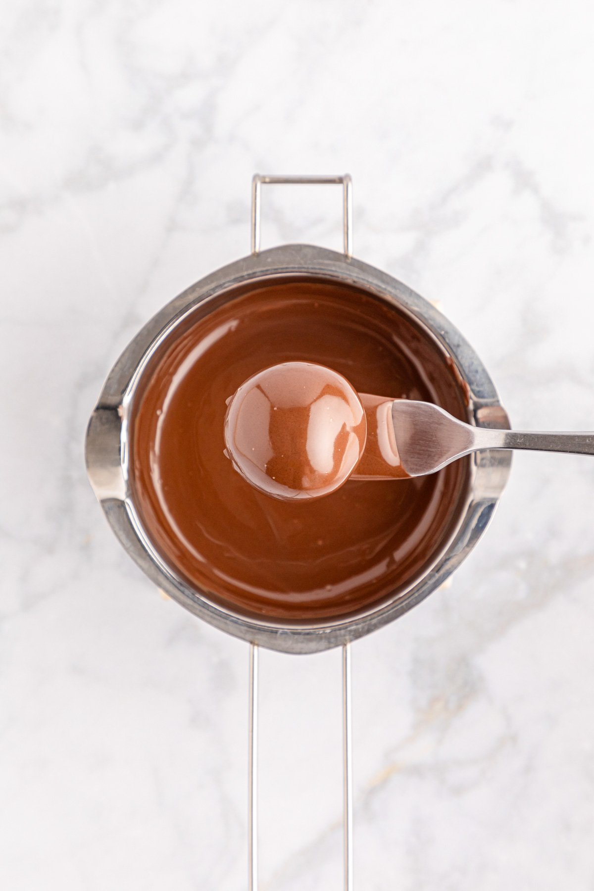 Overhead photo of an oreo ball that's been dipping in melted chocolate.