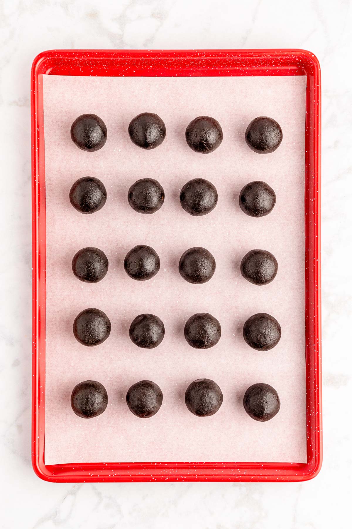 Oreo balls on a parchment lined baking sheet.