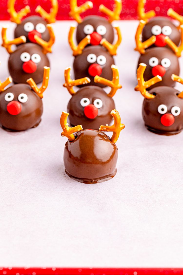 Reindeer Oreo Balls being assembled on a parchment lined baking sheet.