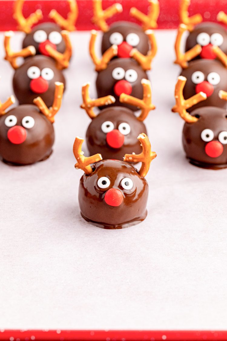 Reindeer Oreo Balls being assembled on a parchment lined baking sheet.