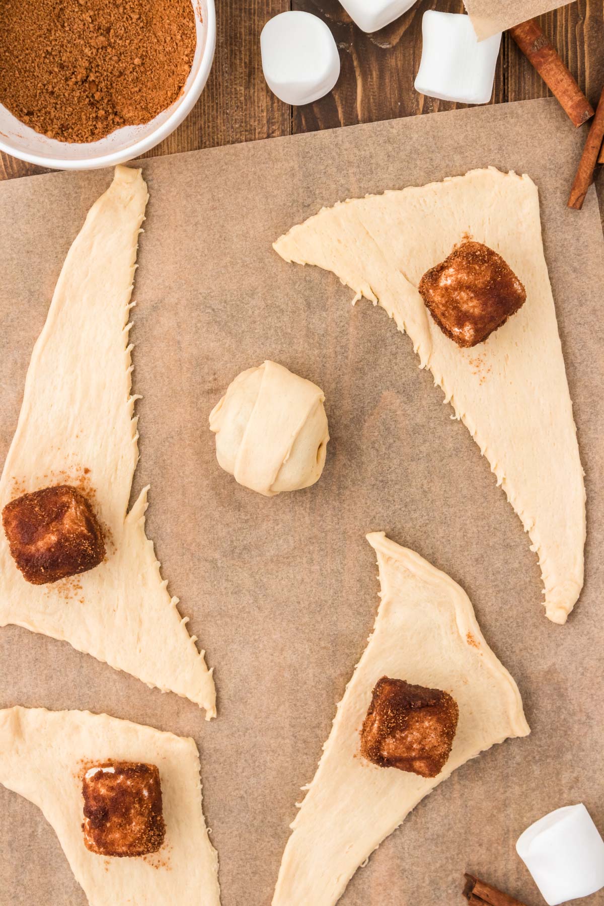 Overhead photo of resurrection rolls being made on a piece of parchment paper. 