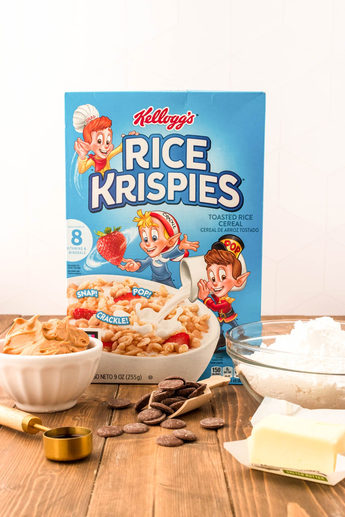 Ingredients to make Rice Krispies Peanut Butter Balls on a wooden table.