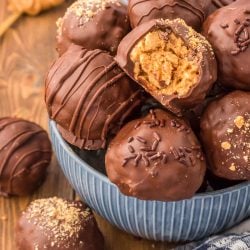 Peanut Butter Balls in a blue bowl, one is missing a bite.