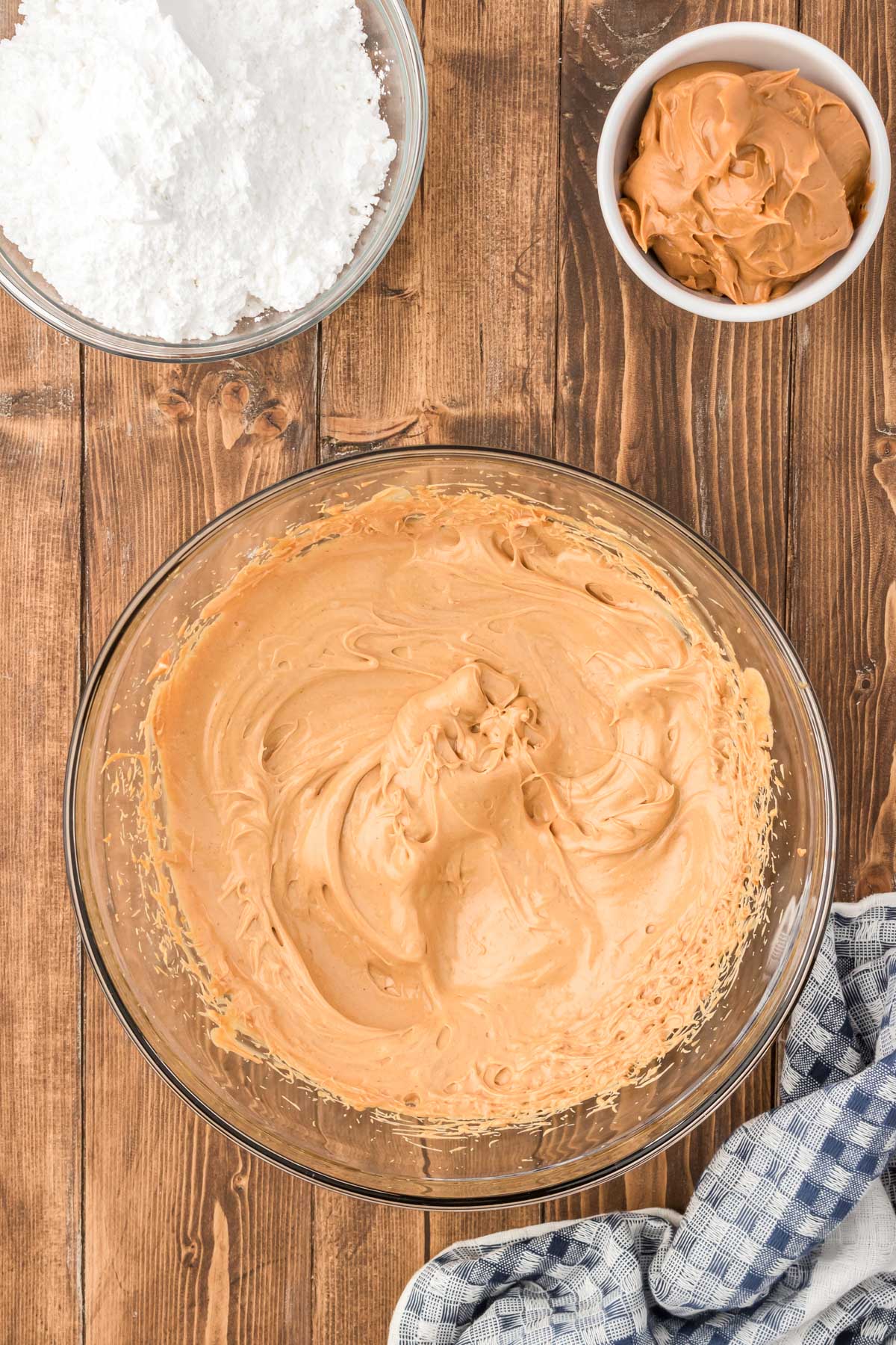 Peanut butter, butter, and vanilla mixed in a glass mixing bowl.