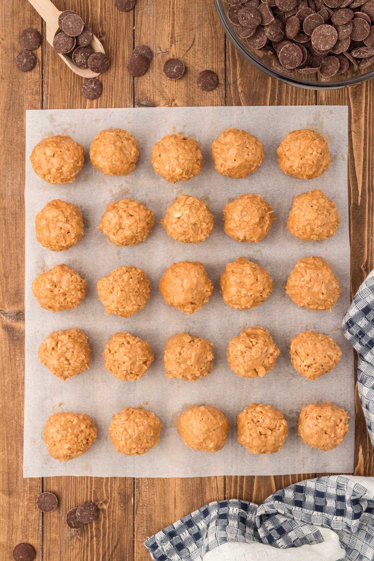 Peanut butter balls rolled and on a parchment lined baking sheet.