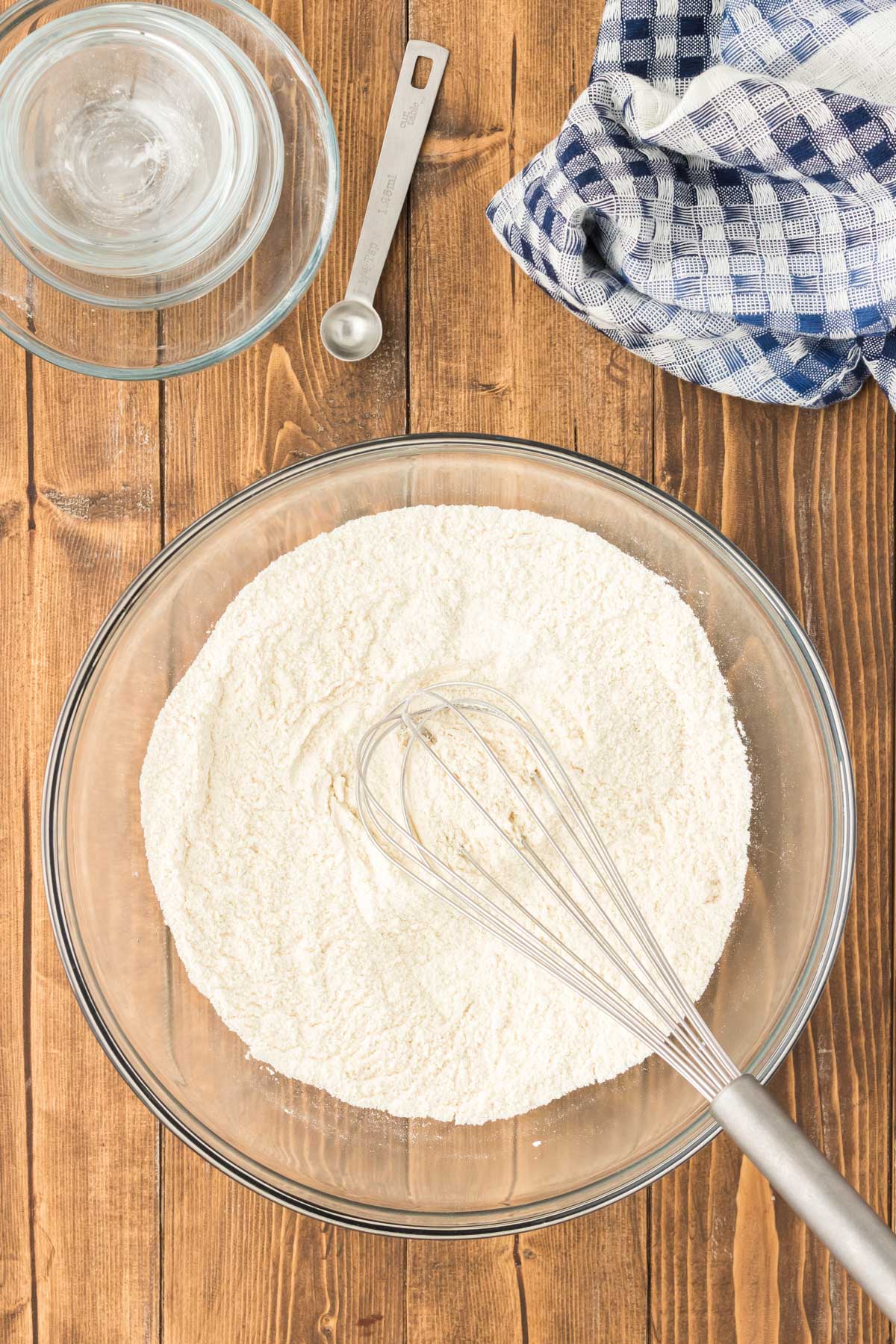 Dry ingredients being whisked together in a glass mixing bowl.