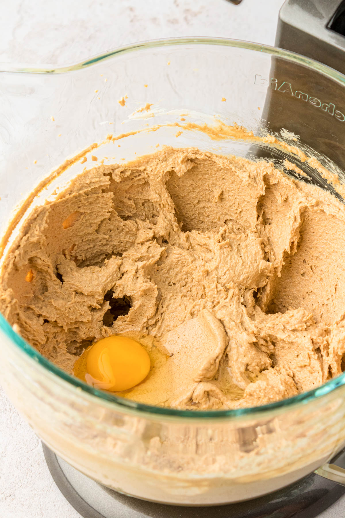 Egg being added to cookie dough.