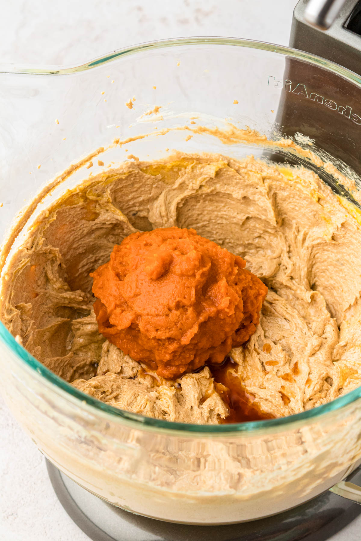 Pumpkin puree being added to cookie dough.