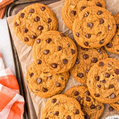 Pumpkin chocolate chip cookies on a cookie sheet.