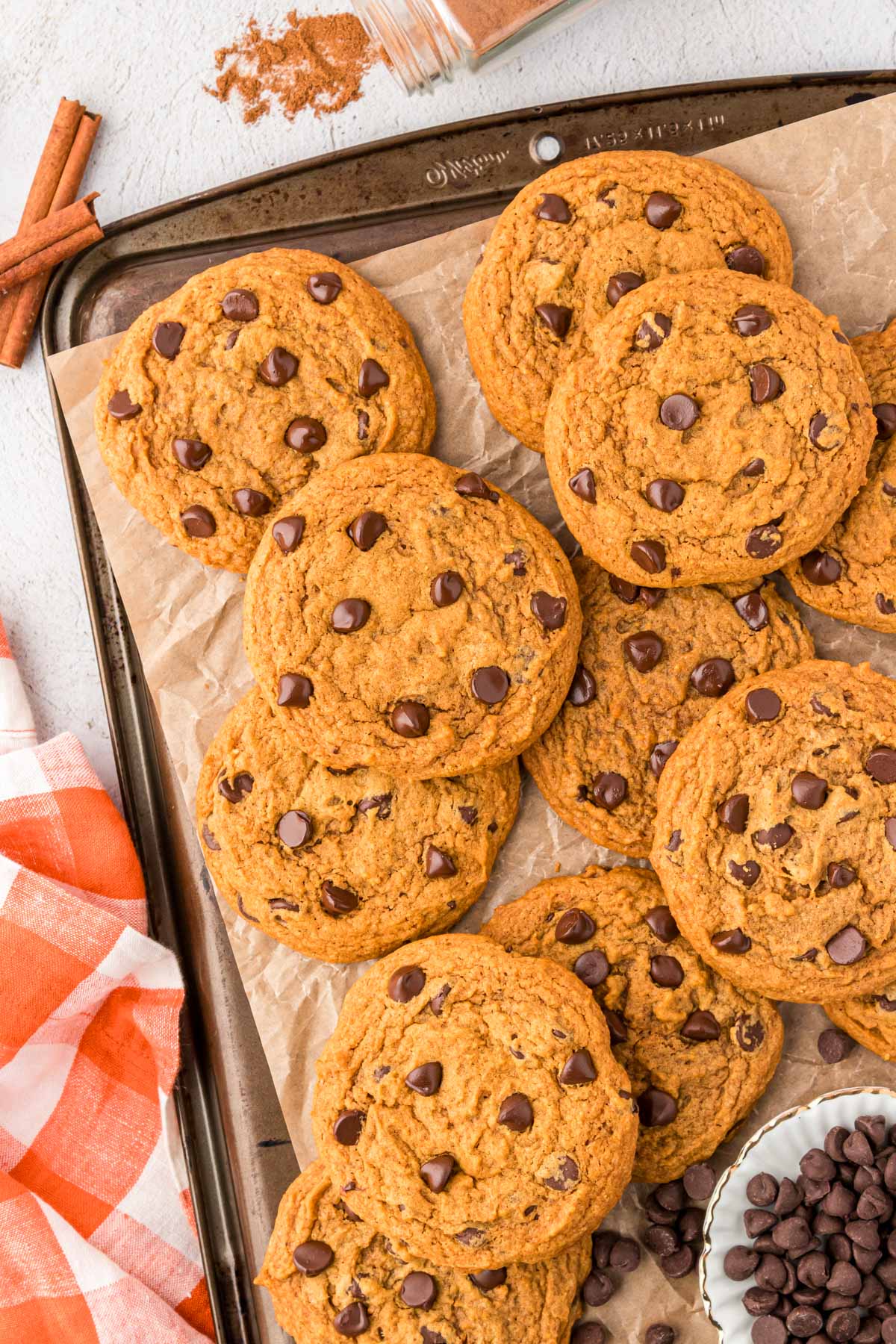 Pumpkin chocolate chip cookies on a cookie sheet.