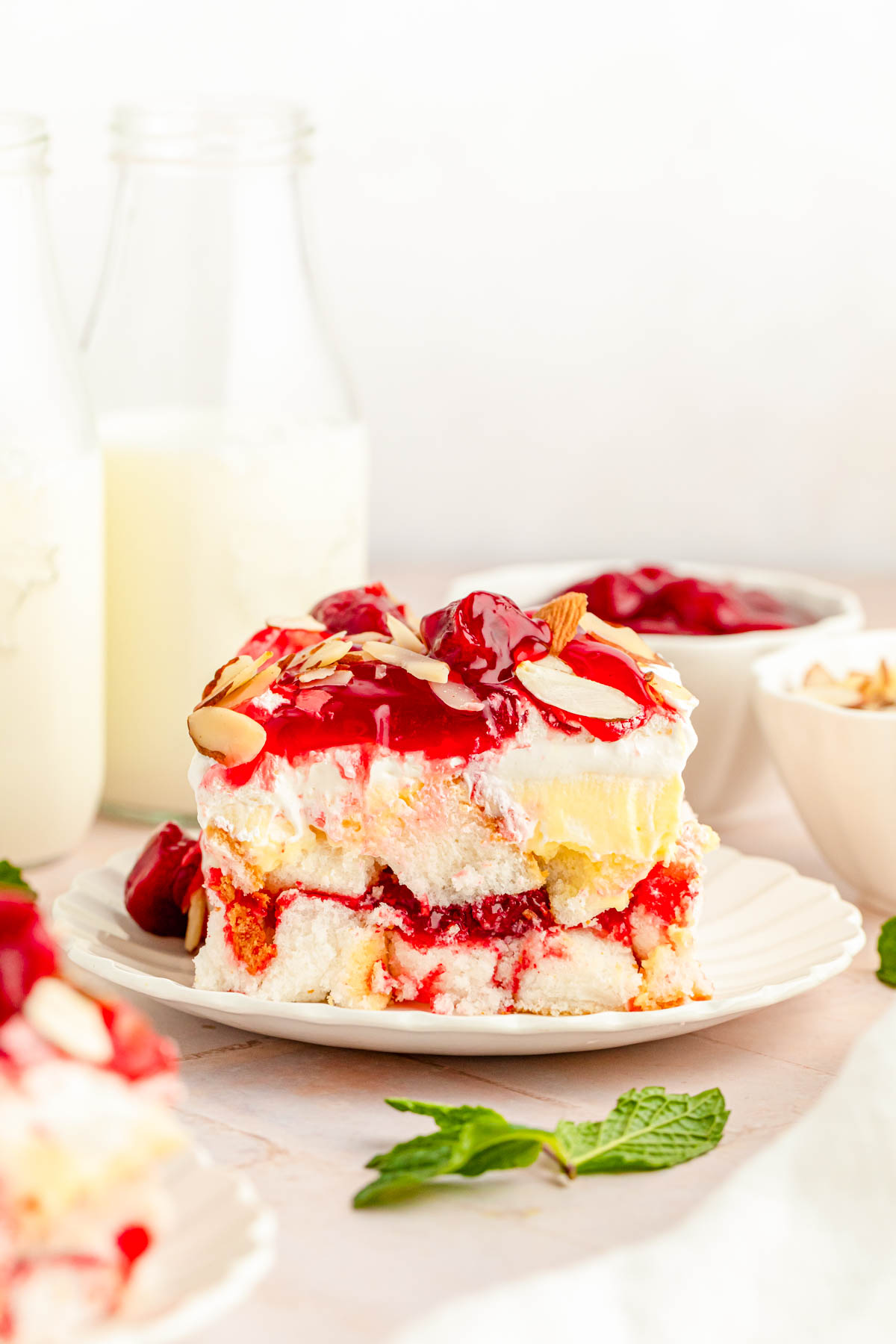 A slice of heaven on earth cake with strawberries on a white plate.