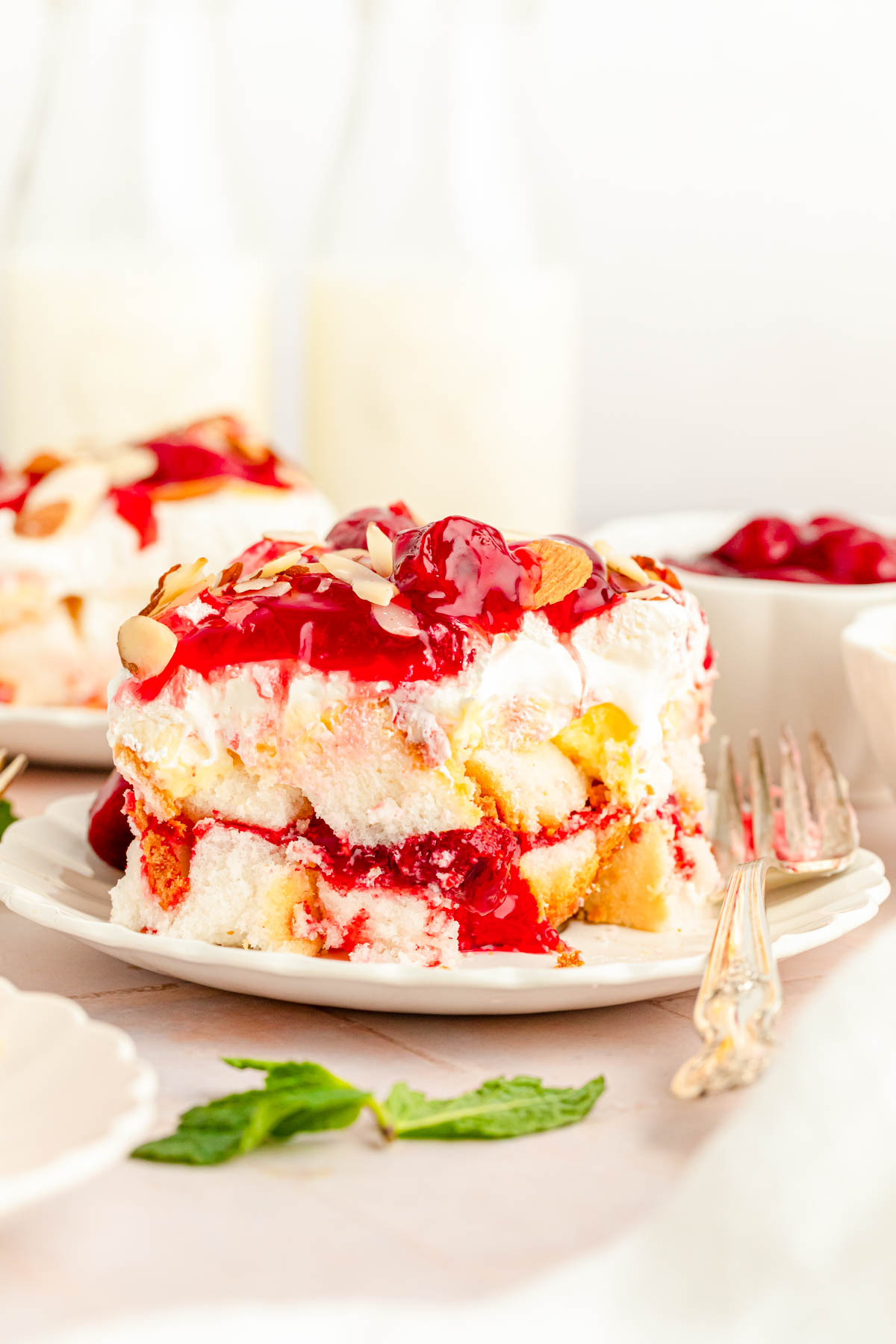 A slice of heaven on earth cake with strawberries on a white plate.