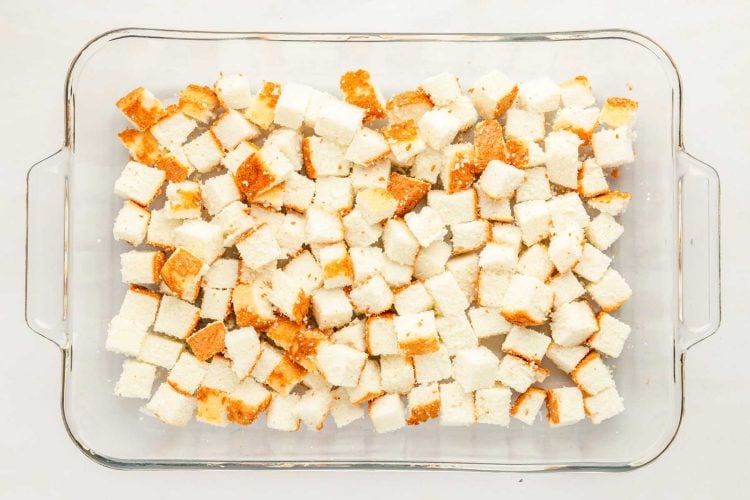 Cubed angel food cake in a glass dish.