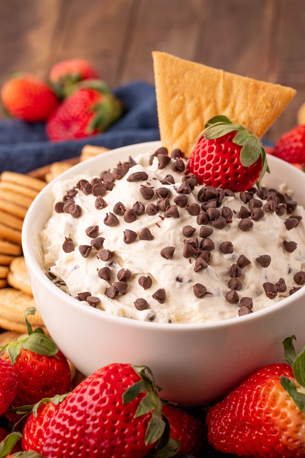 Close up of booty dip in a white bowl with fruit and cookies around it for dipping.