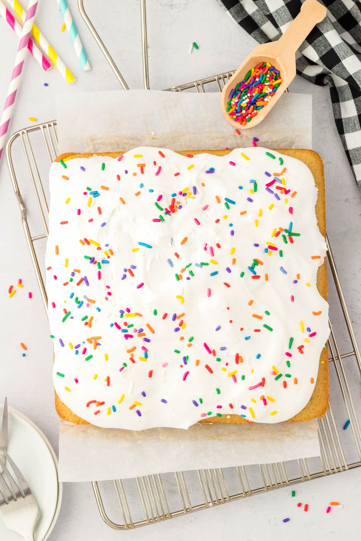 Overhead photo of a square vanilla cake on a wire rack.