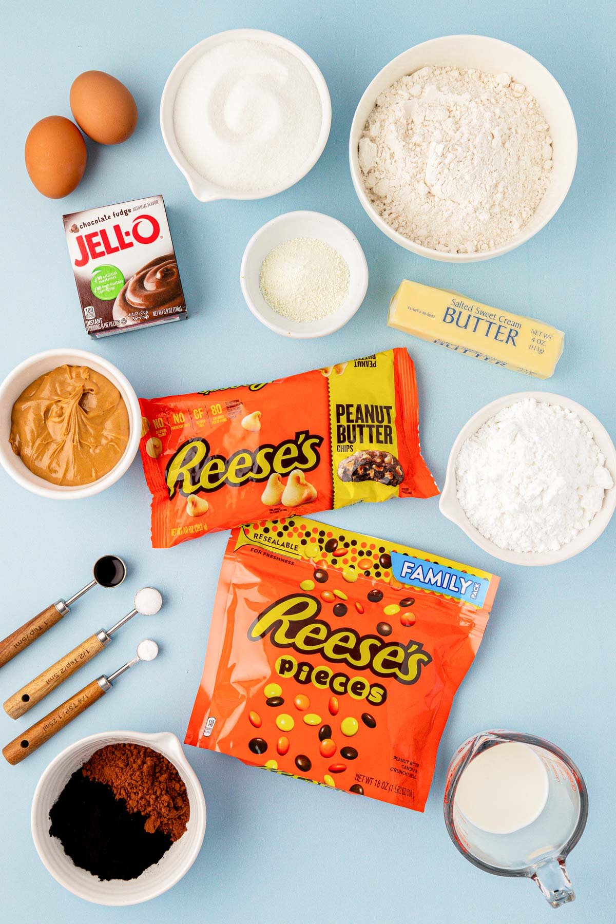 Overhead photo of ingredients to make chocolate peanut butter cookies on a blue table.