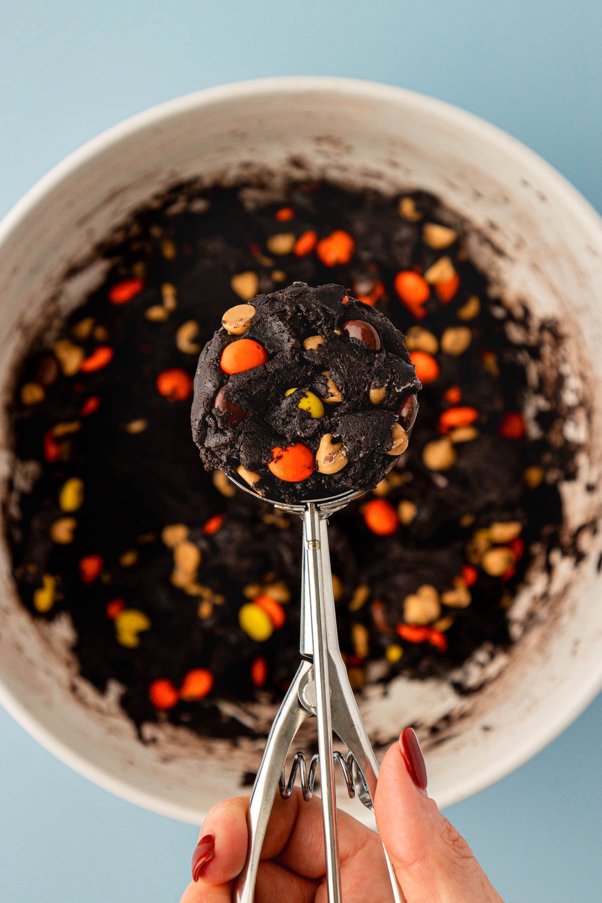 A cookie dough scoop filled with chocolate peanut butter cookie dough in it.