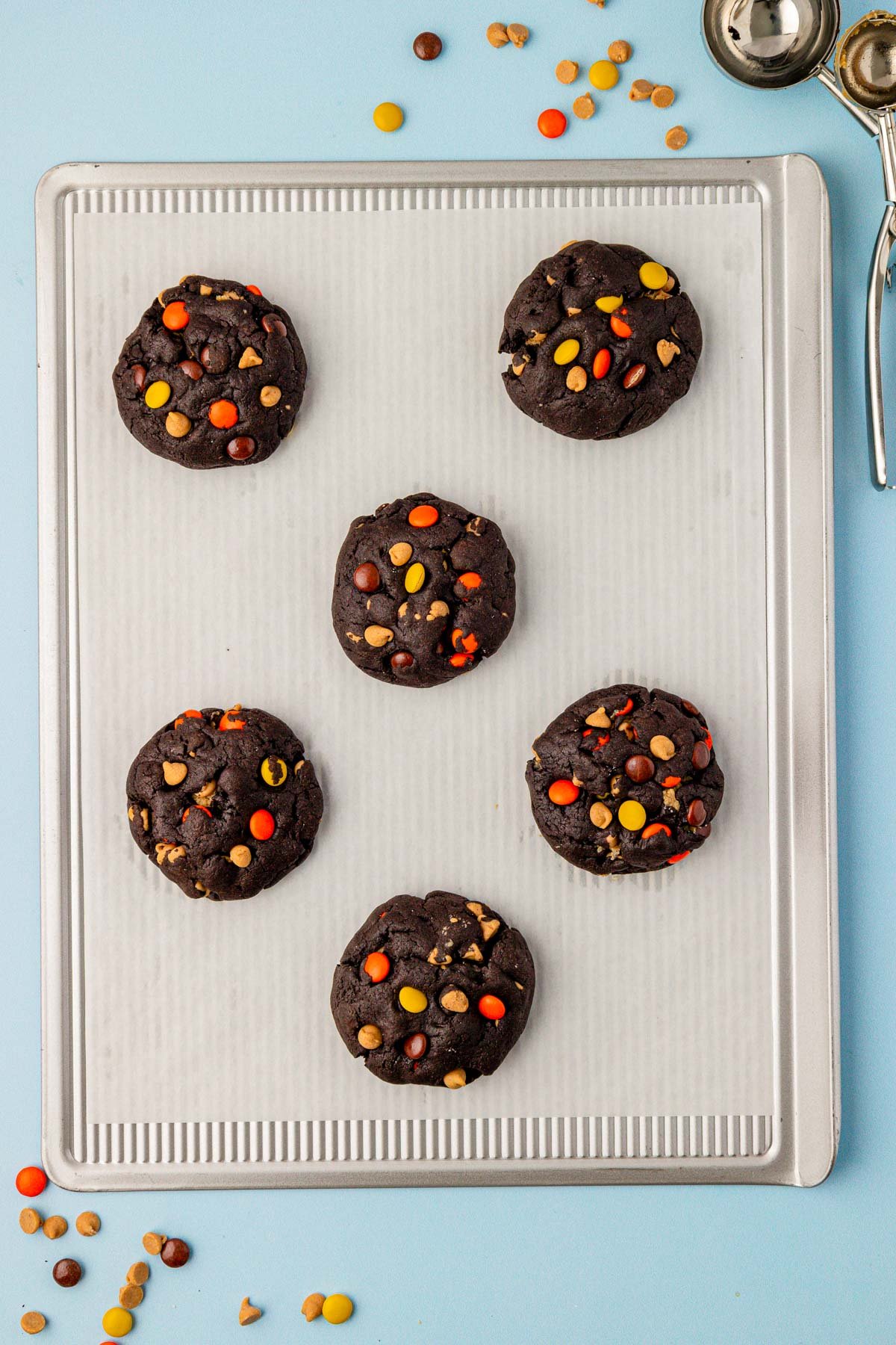 Overhead photo of chocolate peanut butter cookies on a baking sheet lined with parchment paper.