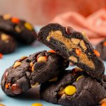 Chocolate peanut butter cookies on a blue table.