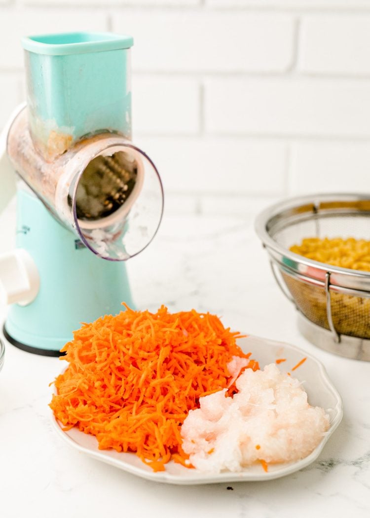 Carrots and onion on a plate after being grated.