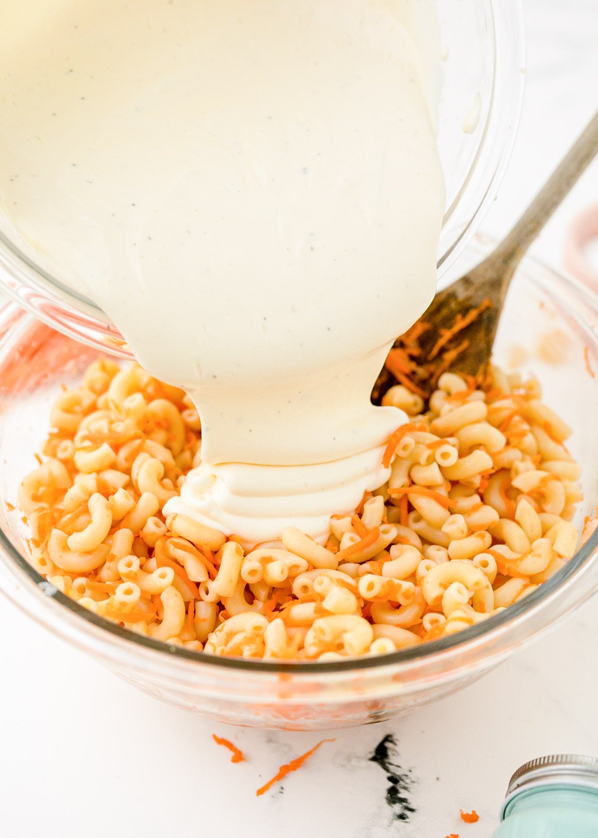 Dressing being poured over Hawaiian Pasta Salad.