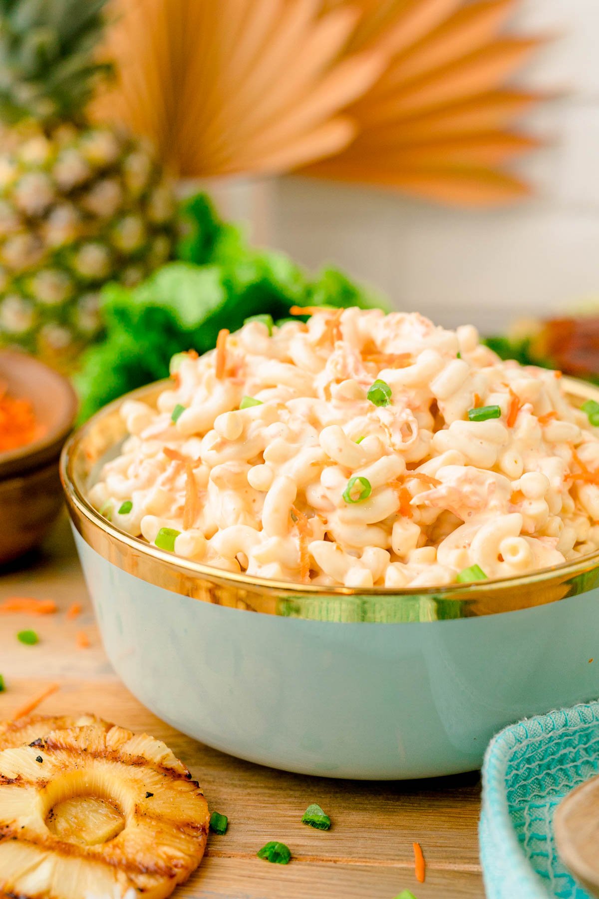 A teal bowl filled with Hawaiian macaroni salad.