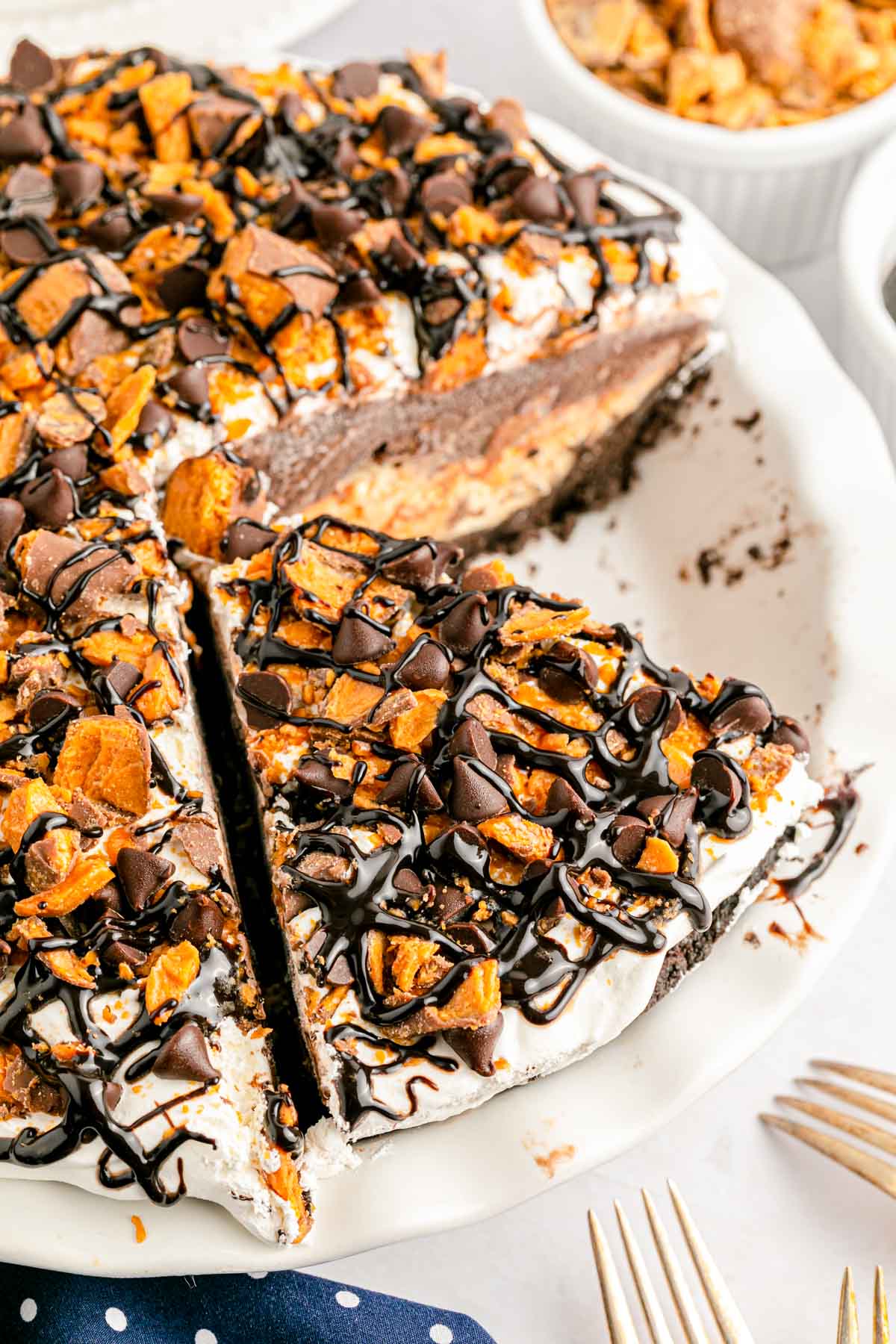 Overhead photo of a butterfinger no bake pie in a white pie dish with a slice missing.