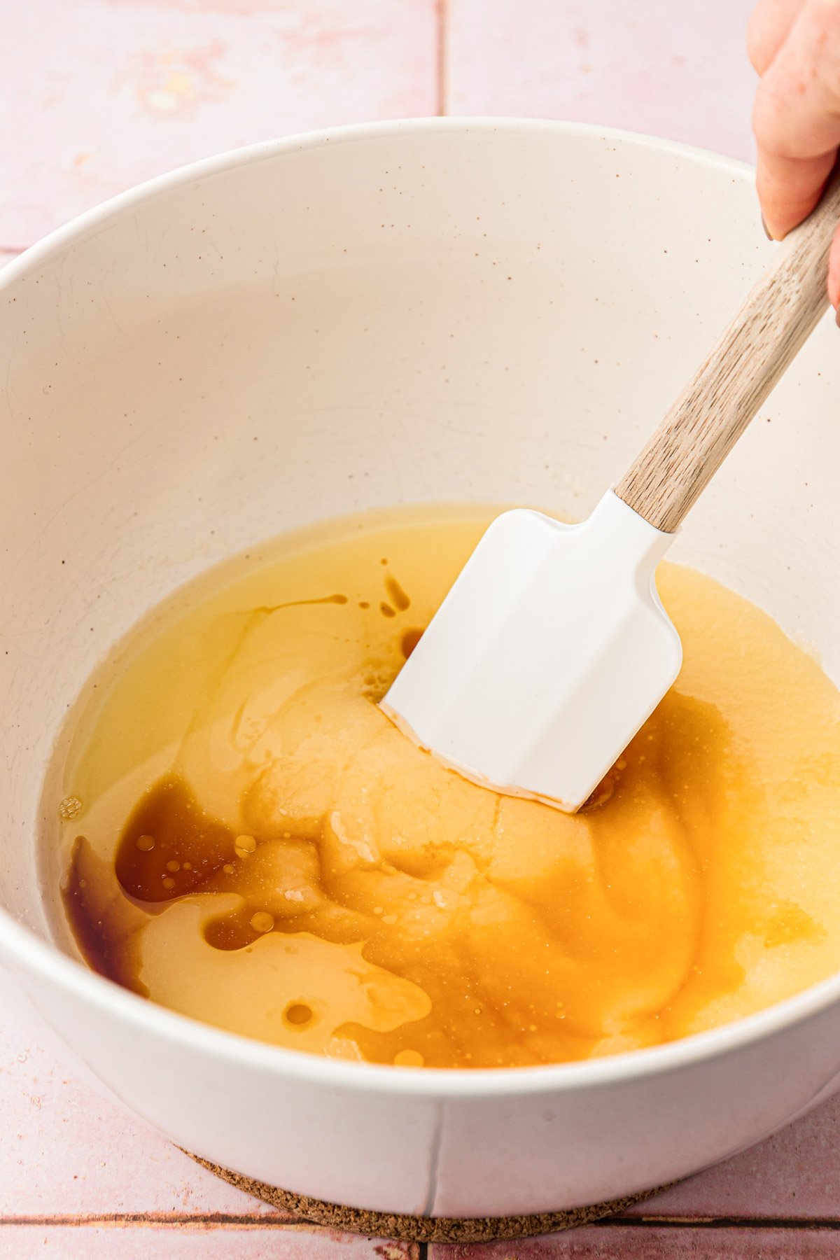 Vanilla being mixed into melted butter and sugar.