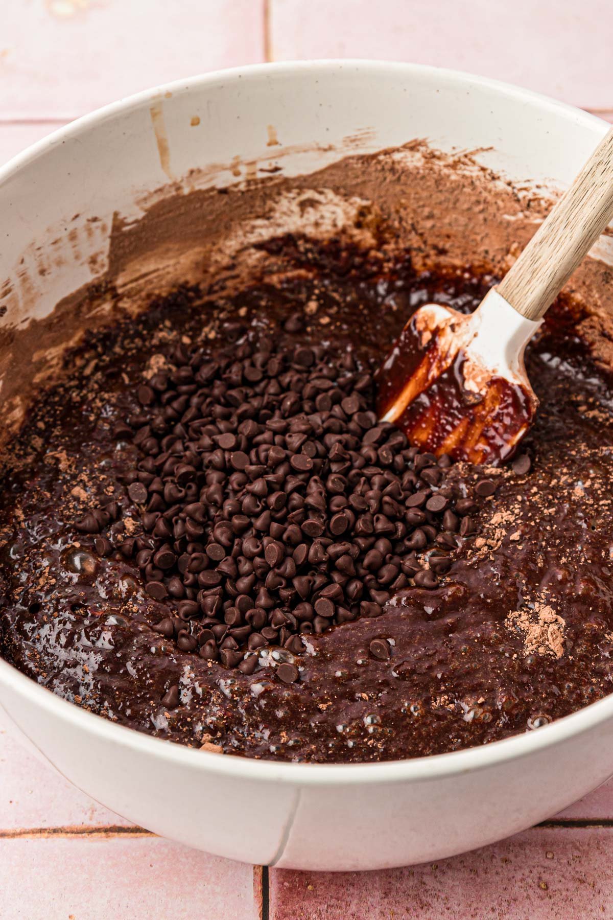 Mini chocolate chips being added to brownie batter.