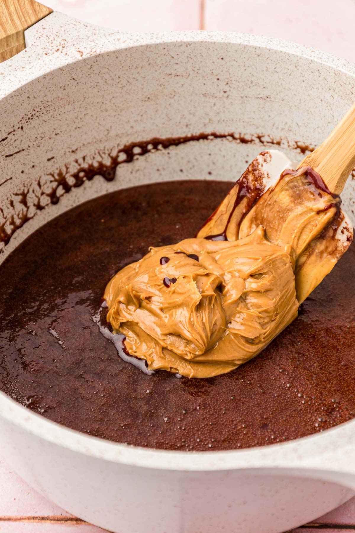 Peanut butter being added to a chocolate sugar mixture to make no bake cookies.