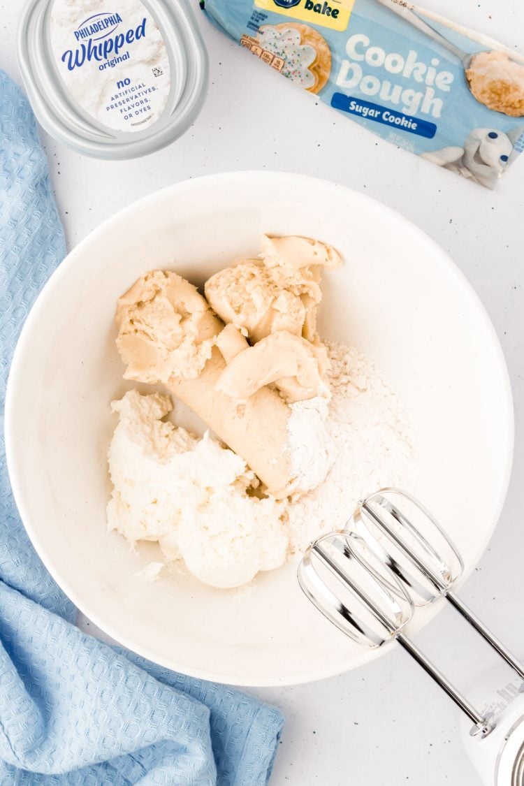 Cookie dough and cream cheese in a white bowl ready to be mixed.