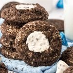 A stack of Oreo thumbprint cookies with one leaning against it.