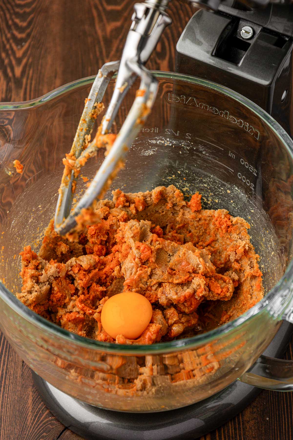 Egg being added to pumpkin cookie dough.